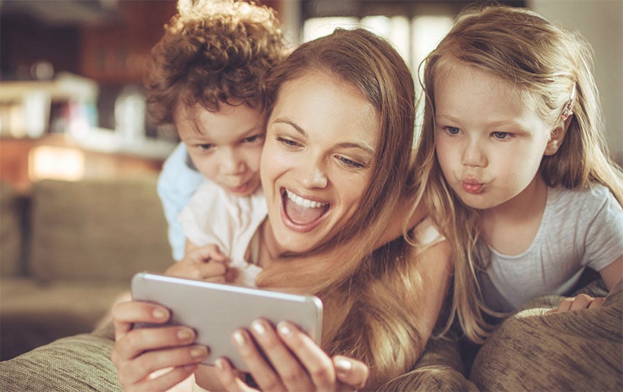 mom with two children on ipad